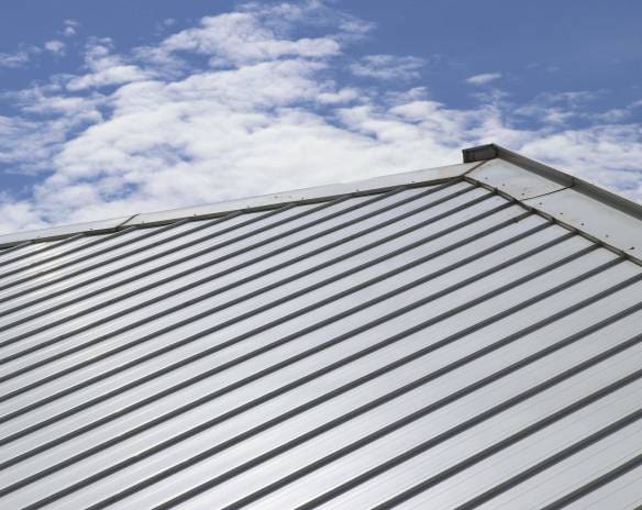 Gray roof slope against a blue sky