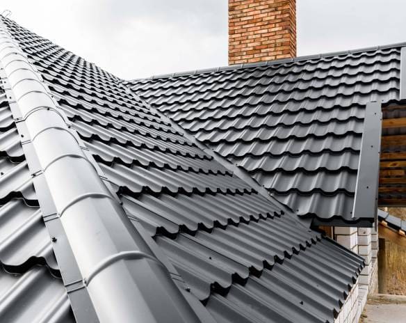Standing seam metal roof panels along a ridge